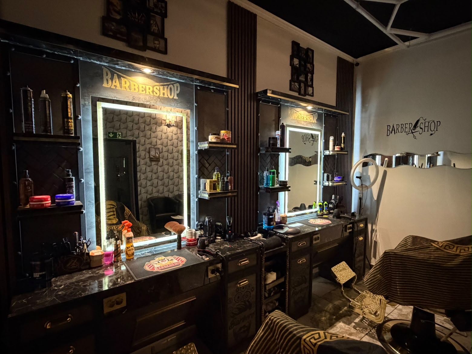 Moudi Barbershop mit beleuchteten Spiegeln und goldenen Barberstühlen